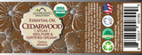 US Organic Cedarwood Atlas essential oil 15 mL wraparound label with safety information and barcode.